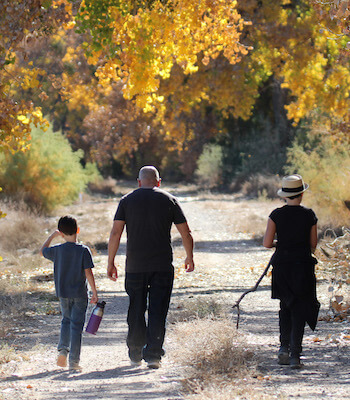 Family walking through Valle de Oro Paseo del Bosque Trail