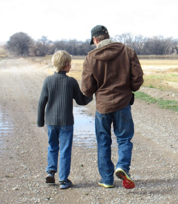 Father and son walking through Calle de Oro