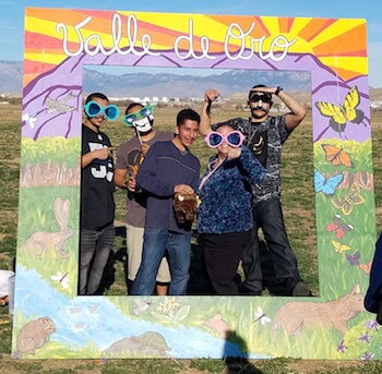 Group holding Valle de Oro sign